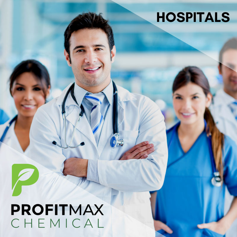 An image of four medical professionals with a light blue and white background that is blurred of a hospital in the background. In the upper right corner is a transparent white triangle with the text in the middle in a black font that reads hospitals. In the lower right corner is the ProfitMax Chemical logo with the green P and the text that reads ProfitMax Chemical. There are four professionals, two men and two women in the middle of the image. The man on the far right is off to the right in a lab coat with a tie and short hair smiling with half his face cut off. A woman is next to him in a blue scrub top with a stethoscope smiling with a pony tail and her hands in her scrubs. The man in the front of the image has a white lab coat, a smile on his face with his hands crossed wearing a sliver, white and blue striped tie with a stethoscope around his neck and dark brown hair. To the left is a woman who is slightly blurry in the image wearing a blue lab coat, smiling and also has a stethoscope around her neck.